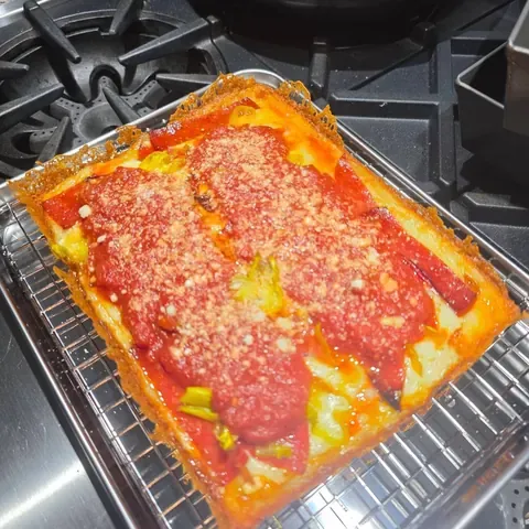 A pepperoni pizza, cut into squares, seen from above